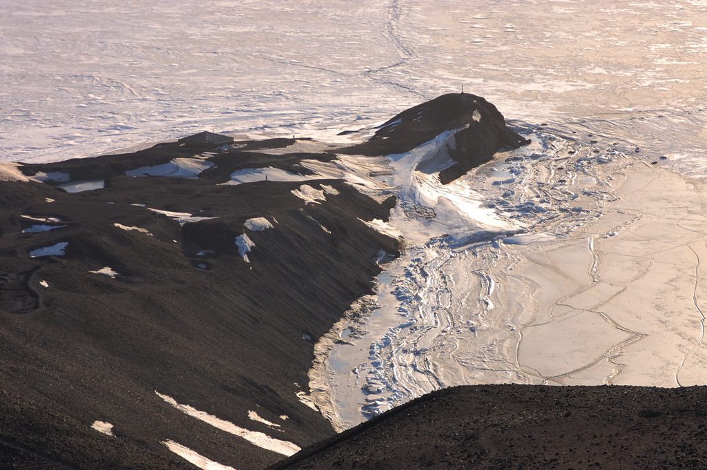 Closer on the Discovery Hut, which can just be seen silhouetted against the ice.