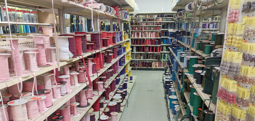 An aisle of trim, organised by colour, at Dressew